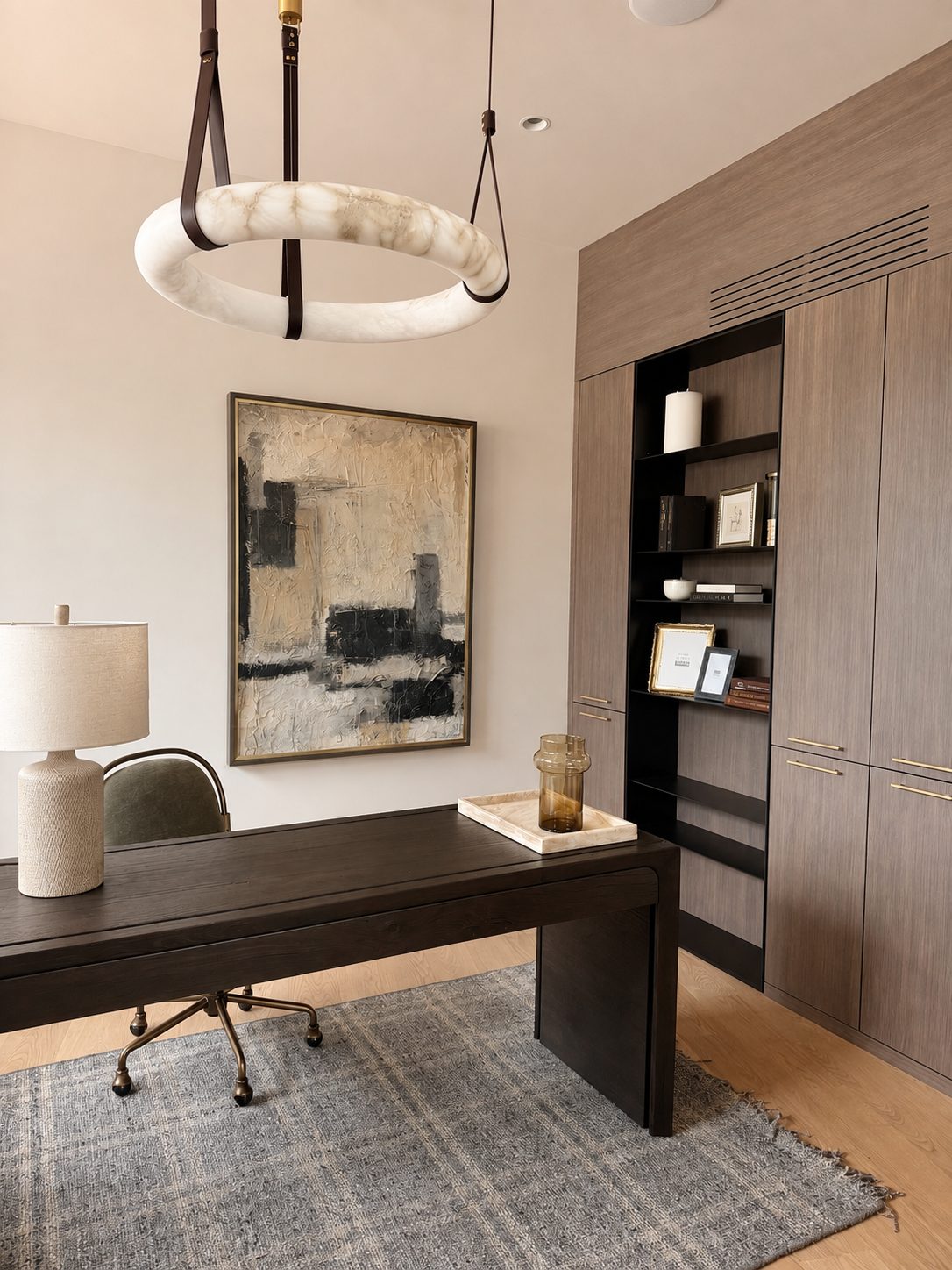 Cream, taupe, and black block abstract painting in a modern home office with a dark wood desk and an alabaster ring chandelier